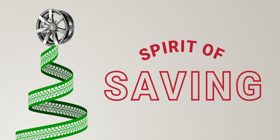 A green ribbon with white tire mark patterns forming a christmas tree. At the top of the tree, a high-polished wheel. To the right, the words: spirit of saving.