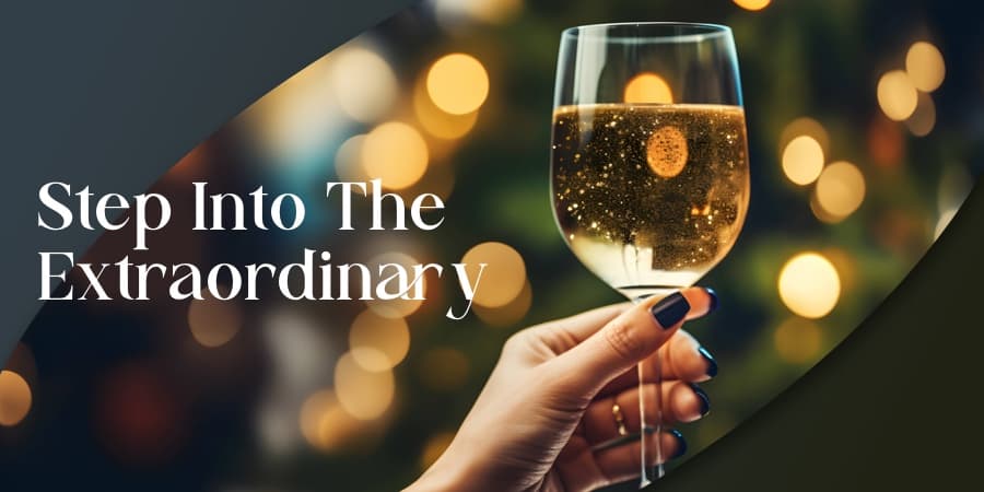 A female hand holding a glass of champagne in front of twinkling lights. To the left the words: step into the extraordinary.