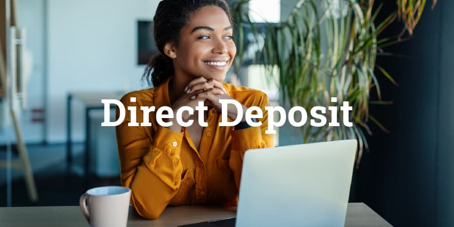 A smiling woman sitting at her desk. In the center, the words: direct deposit.