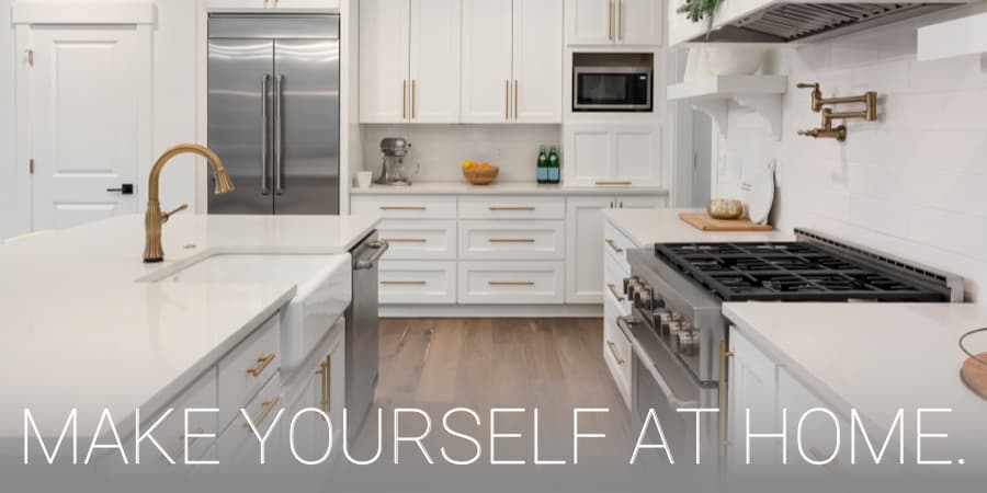 A beautiful, white, modern kitchen. At the bottom, the words: Make Yourself At Home.
