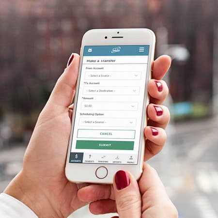 A young woman's hand holding a smart phone showing the CDC FCU mobile app.
