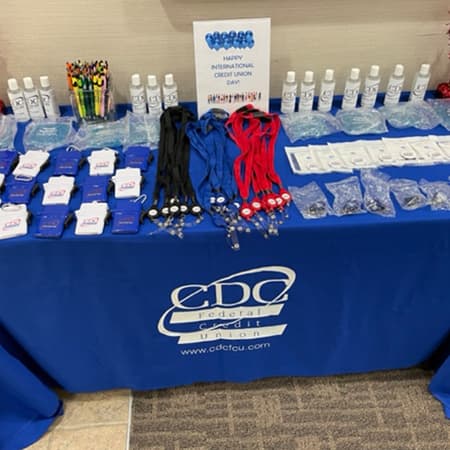 CDC FCU branded giveaways on a folding table.