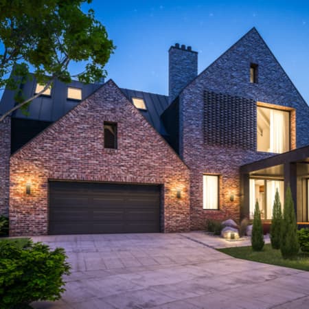 A curb view of a beautiful, brick modern home.