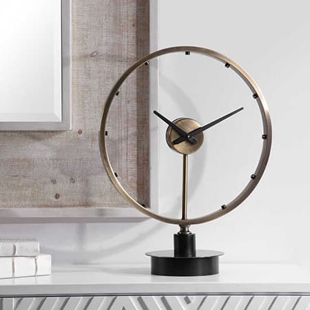 A modern clock sitting on a table top.