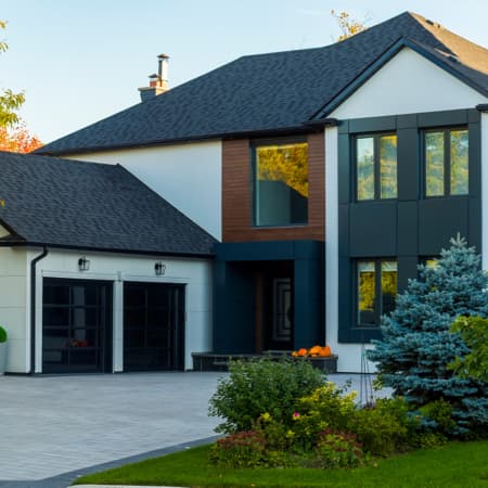 A curb view of a beautiful, white with wood accents modern home.
