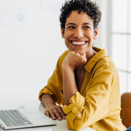 A smiling woman sitting at her desk