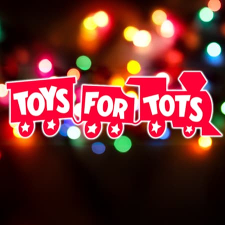 The Toys for Tots logo against holiday lights