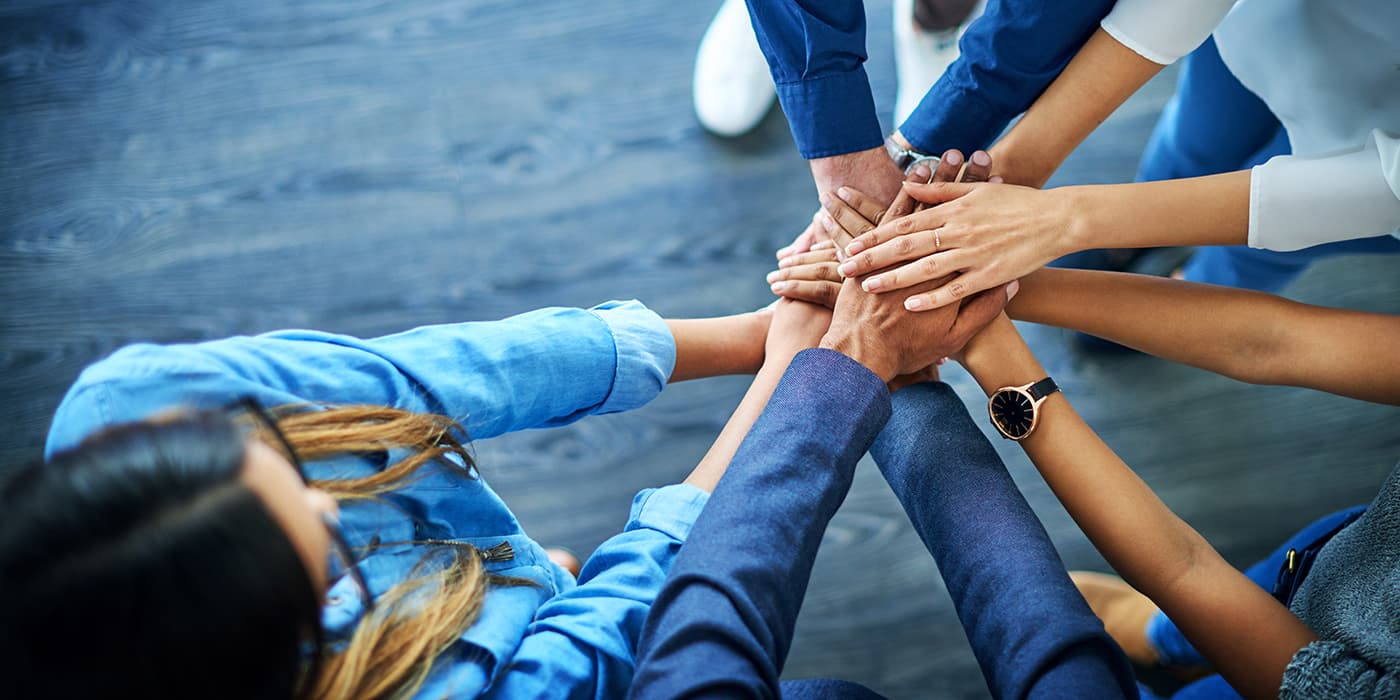 A group of people with hands together.