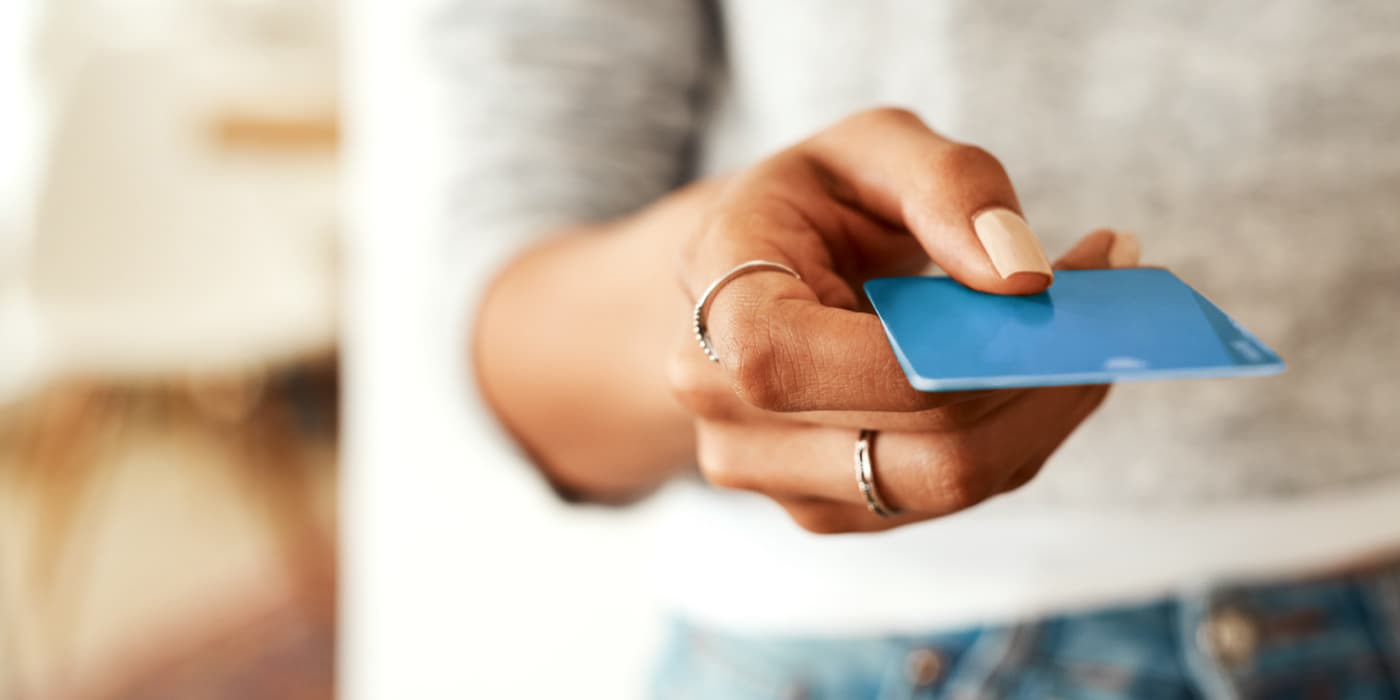 A woman holding a debit card.