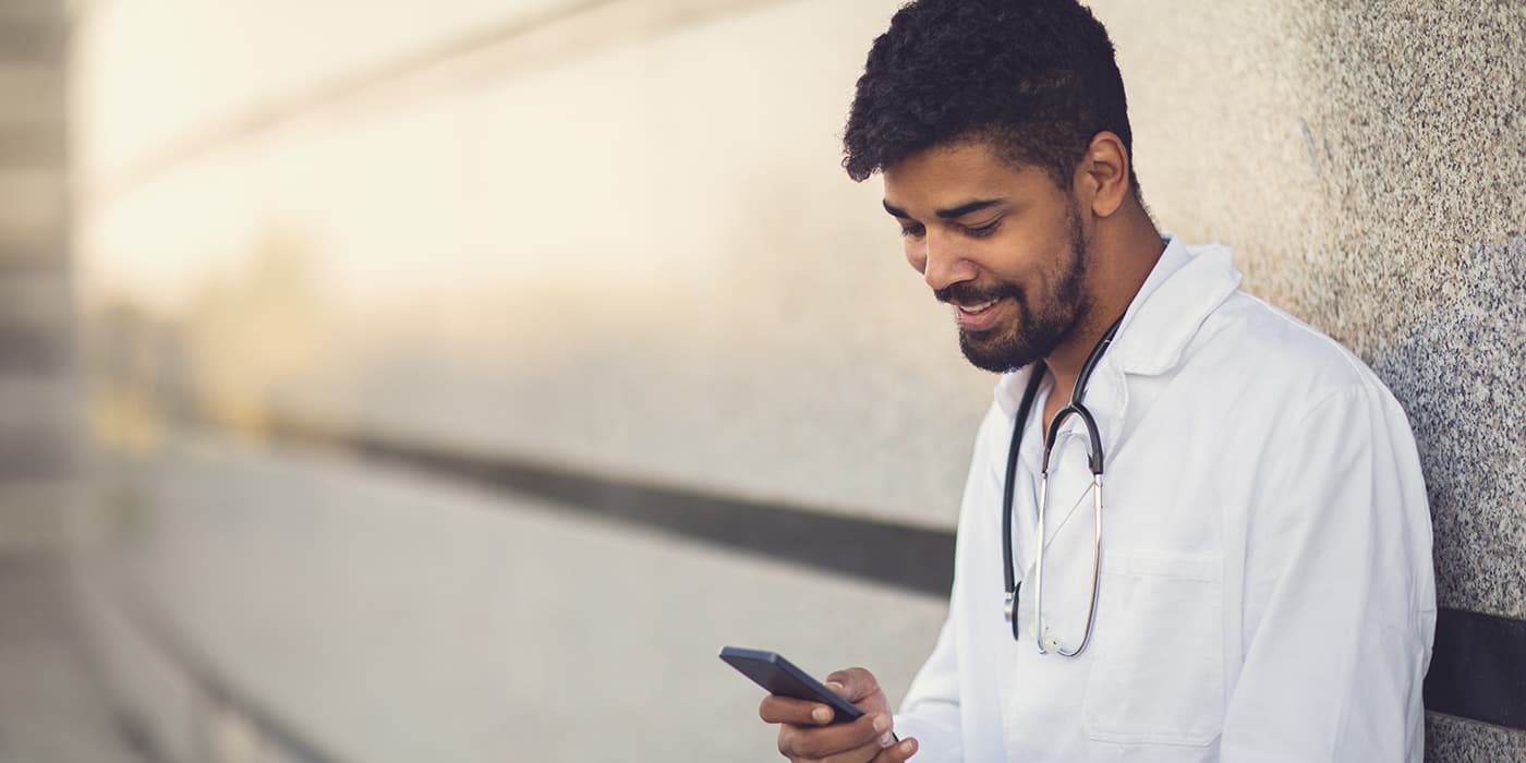 A young healthcare professional using a smartphone.