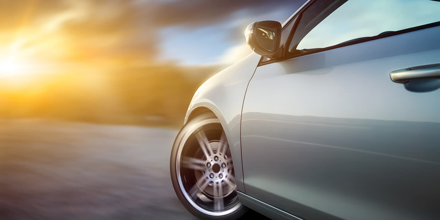 An up-close view of the front wheel of a moving sports car.