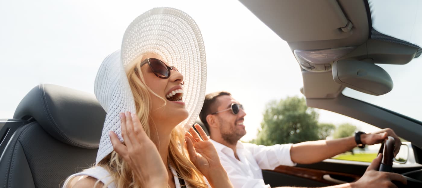 A happy couple driving in a convertible.