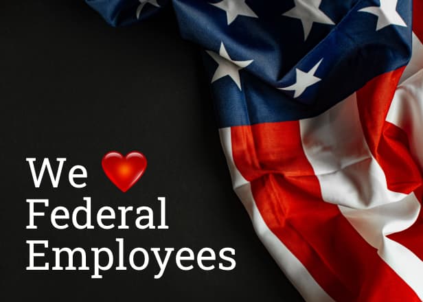 An American flag resting on a dark surface. The words at the bottom left: we heart federal employees.