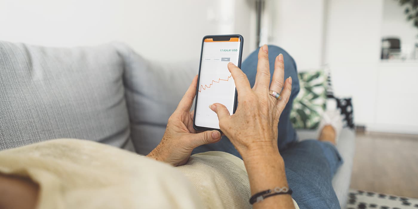 A woman laying on a couch using a smartphone.