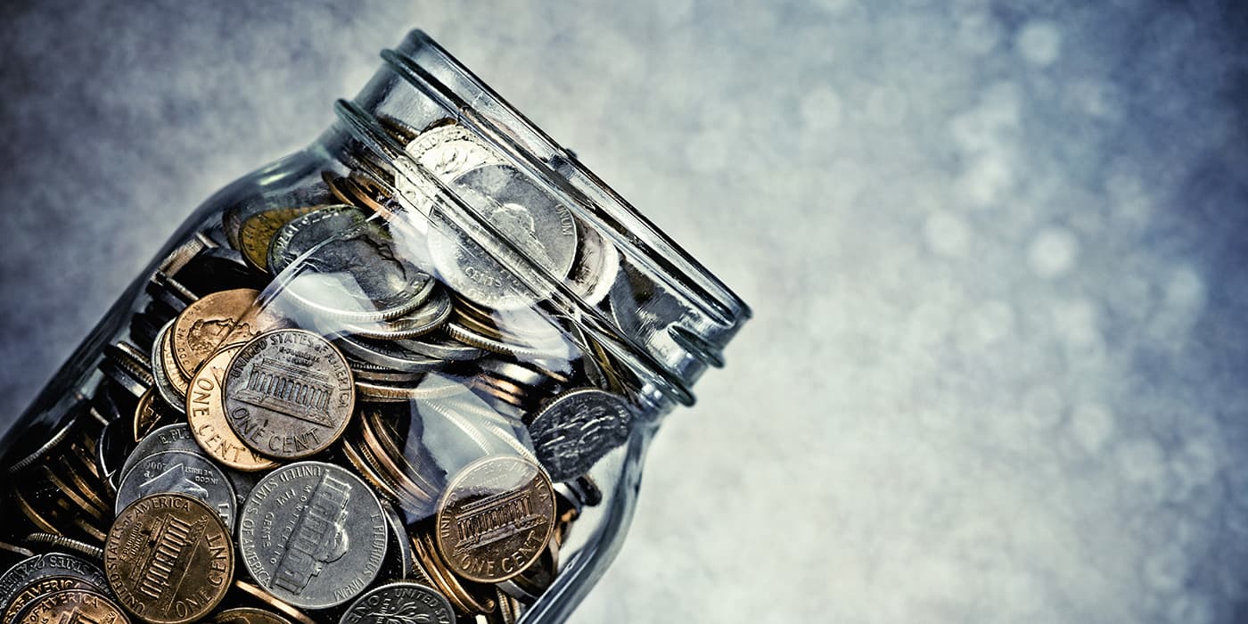 A glass jar full of coins.