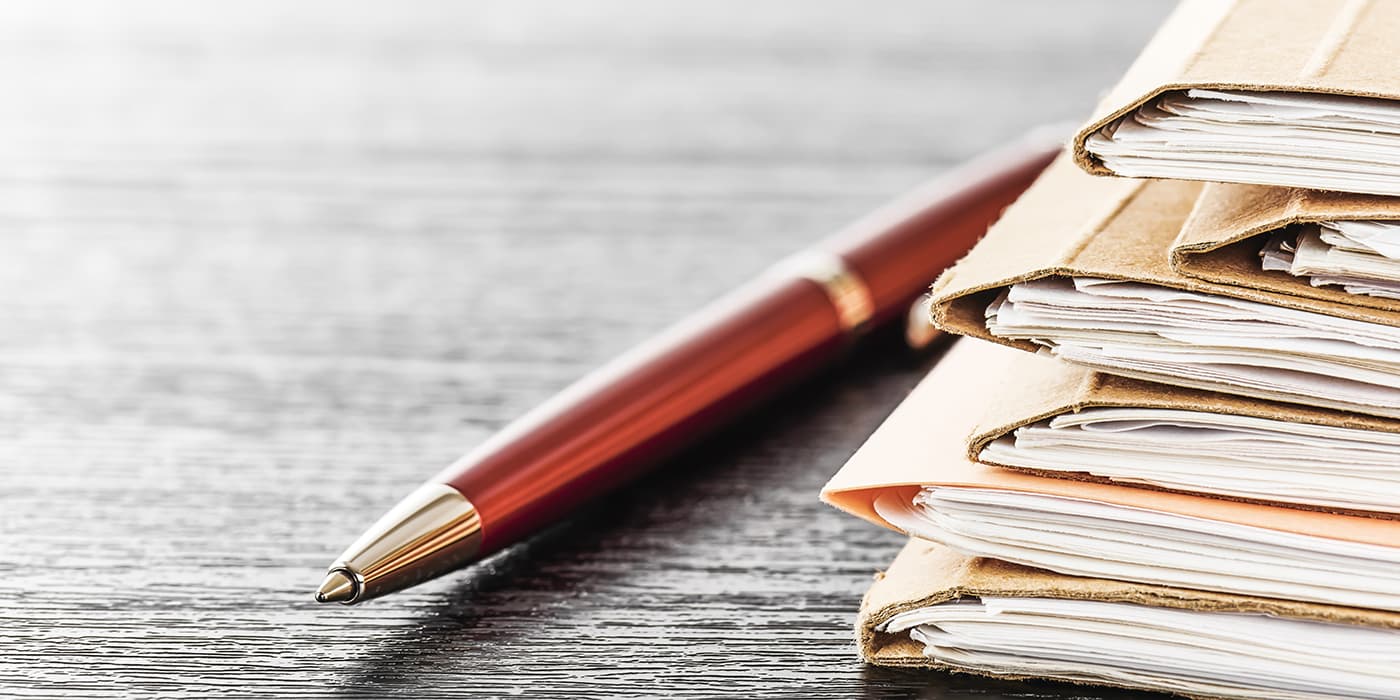 Several folders resting on a wooden table.
